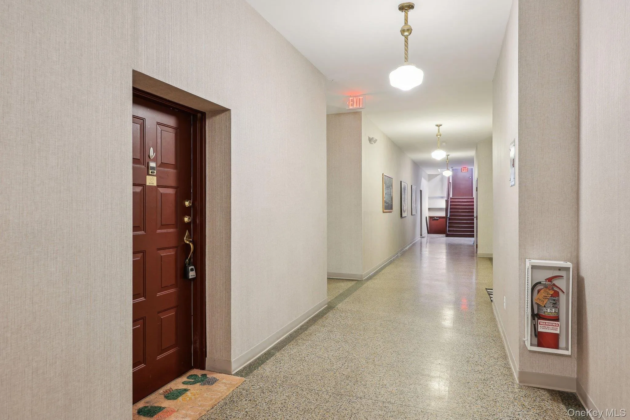 Hallway featuring stairway, baseboards, and speckled floor Hallway featuring stairway, baseboards, and speckled floor