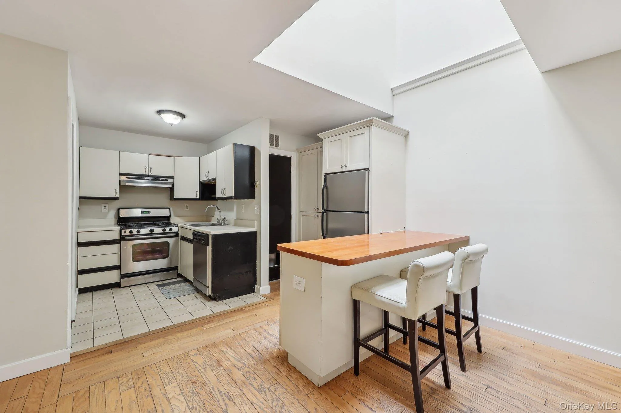 Kitchen featuring a sink, a breakfast bar, light wood-style floors, and stainless steel appliances Kitchen featuring a sink, a breakfast bar, light wood-style floors, and stainless steel appliances