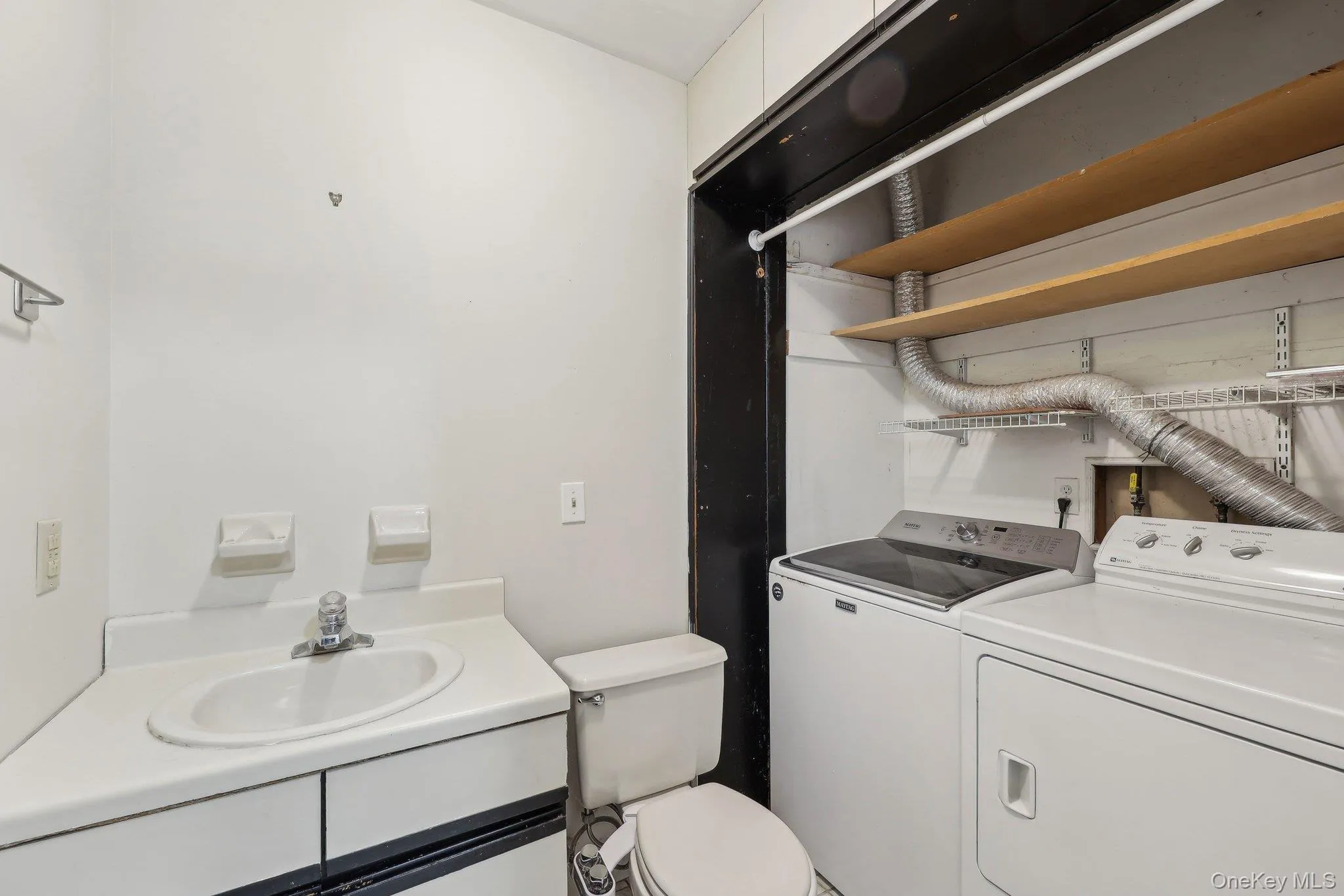 Bathroom featuring a sink, toilet, and washer and clothes dryer Bathroom featuring a sink, toilet, and washer and clothes dryer