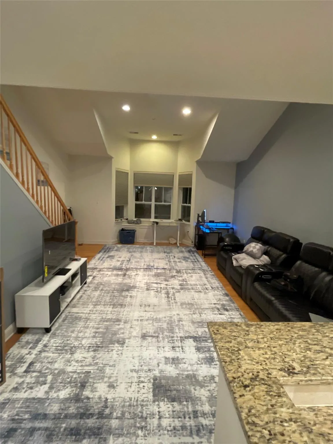 Living room with recessed lighting, stairs, and wood finished floors Living room with recessed lighting, stairs, and wood finished floors