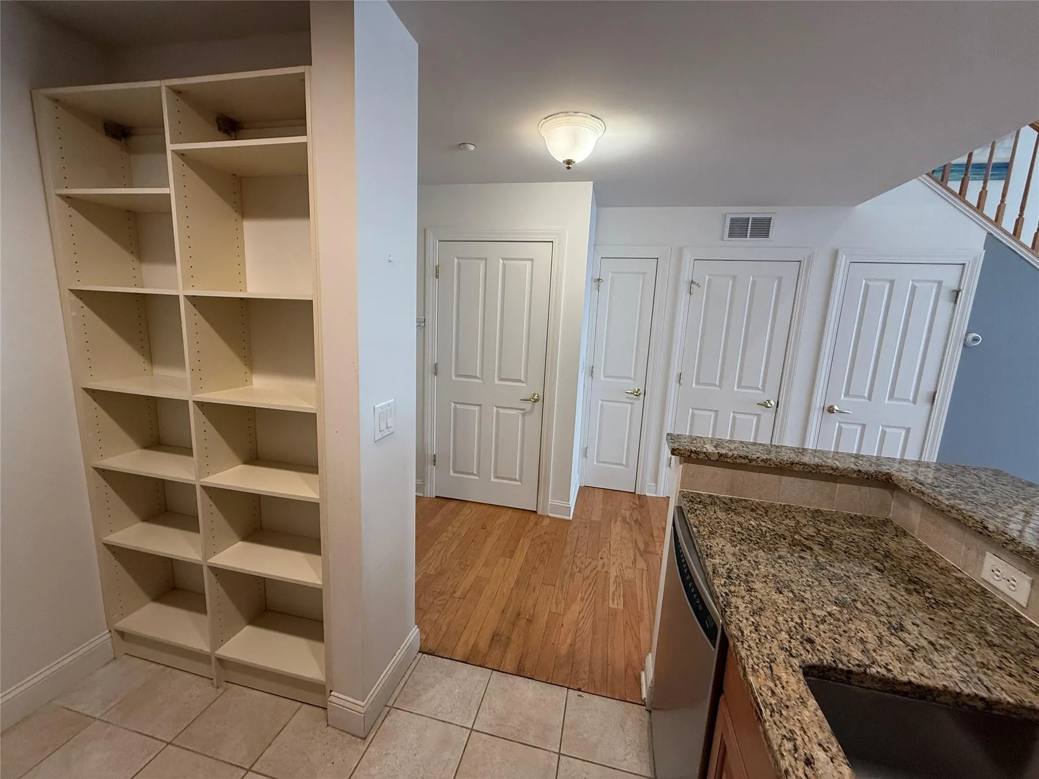 Kitchen with visible vents, dishwasher, baseboards, light stone counters, and light tile patterned floors Kitchen with visible vents, dishwasher, baseboards, light stone counters, and light tile patterned floors