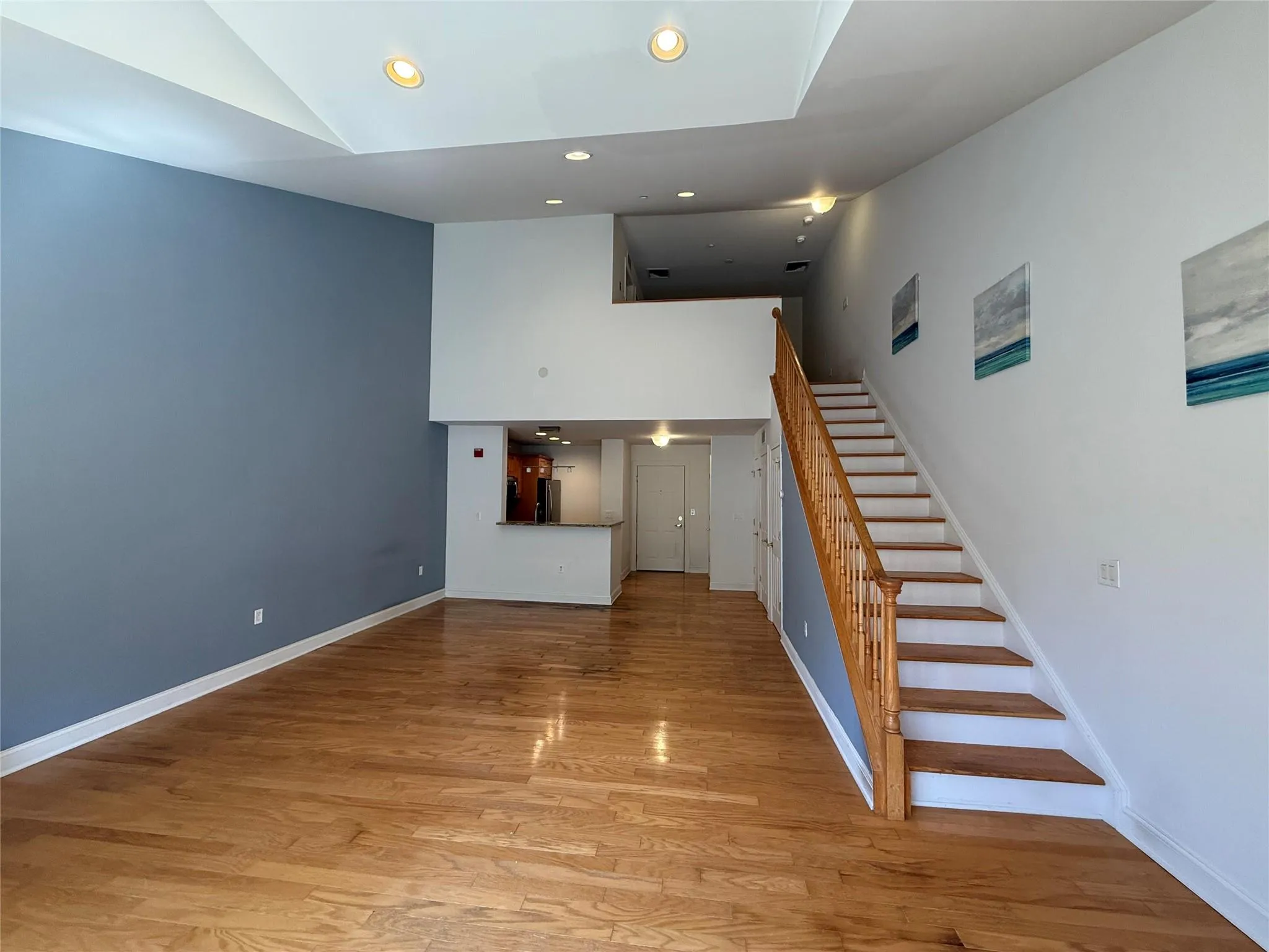 Stairs with high vaulted ceiling, baseboards, recessed lighting, and wood finished floors Stairs with high vaulted ceiling, baseboards, recessed lighting, and wood finished floors
