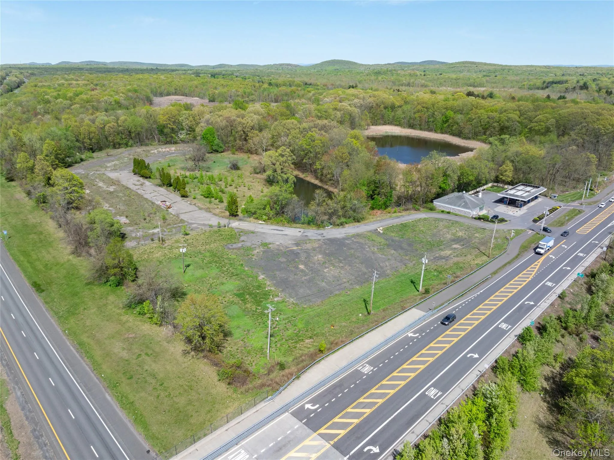 Aerial view featuring a water view and a forest view Aerial view featuring a water view and a forest view