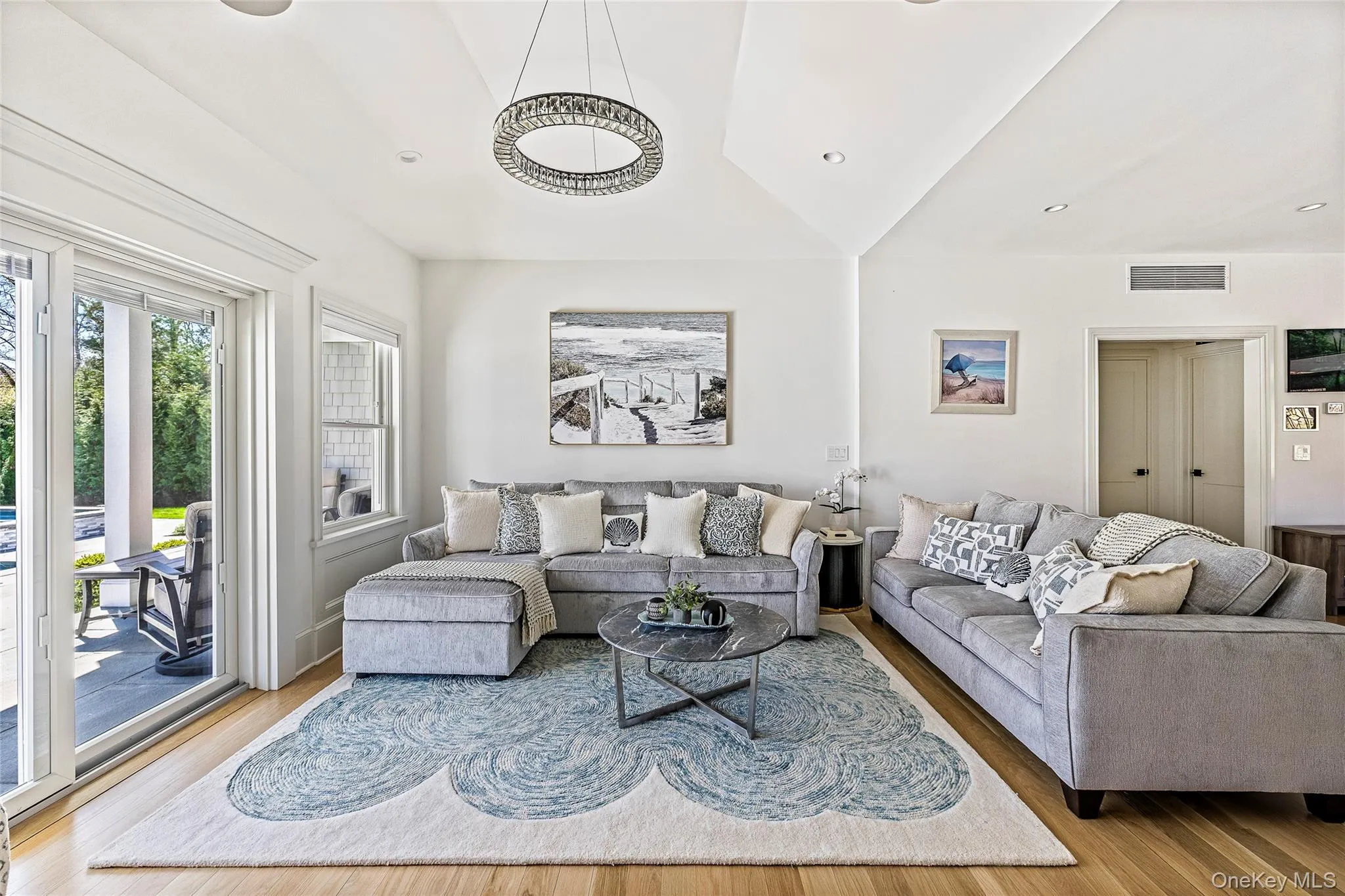 Living area featuring visible vents, wood finished floors, and lofted ceiling Living area featuring visible vents, wood finished floors, and lofted ceiling