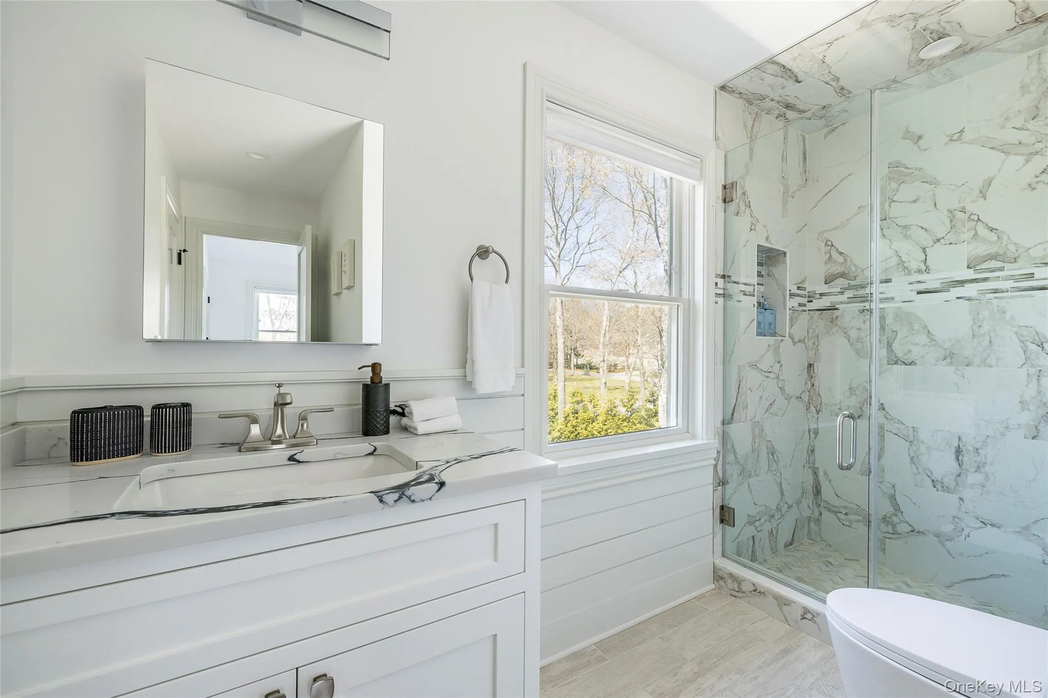 Full bath with toilet, a marble finish shower, and vanity Full bath with toilet, a marble finish shower, and vanity