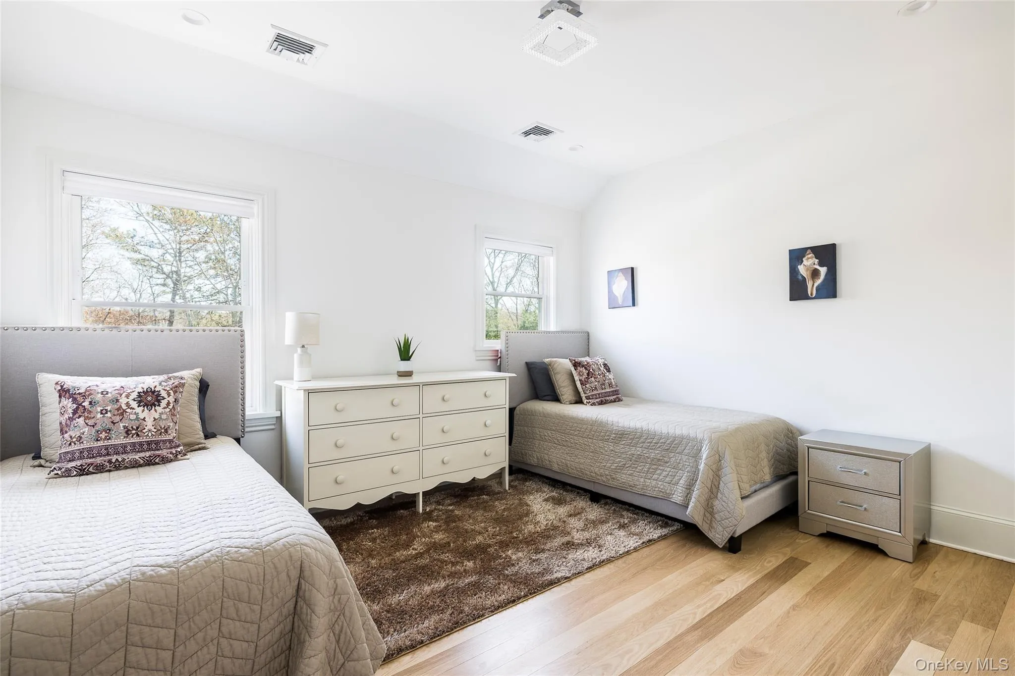 Bedroom featuring baseboards, visible vents, vaulted ceiling, and light wood-style floors Bedroom featuring baseboards, visible vents, vaulted ceiling, and light wood-style floors