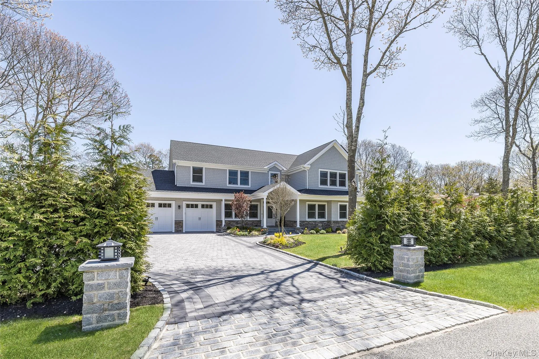 Craftsman-style home featuring a front yard, decorative driveway, and stone siding Craftsman-style home featuring a front yard, decorative driveway, and stone siding