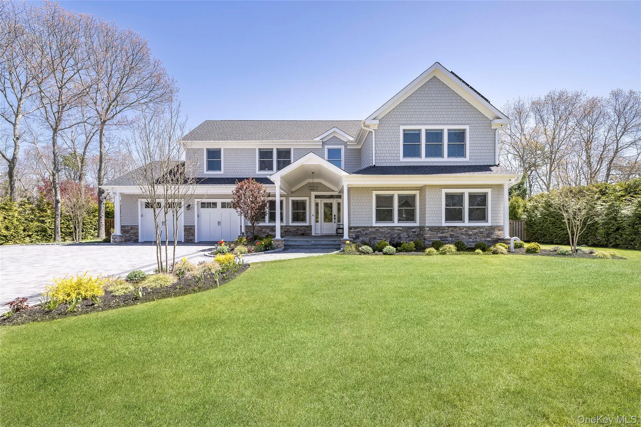 View of front of home featuring a front yard, driveway, french doors, and stone siding View of front of home featuring a front yard, driveway, french doors, and stone siding