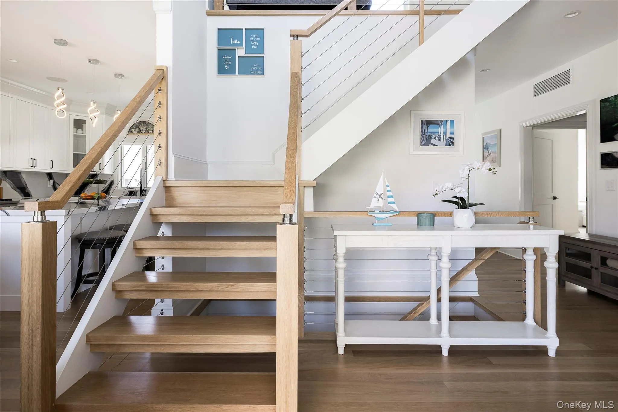 Stairs featuring visible vents and wood finished floors Stairs featuring visible vents and wood finished floors