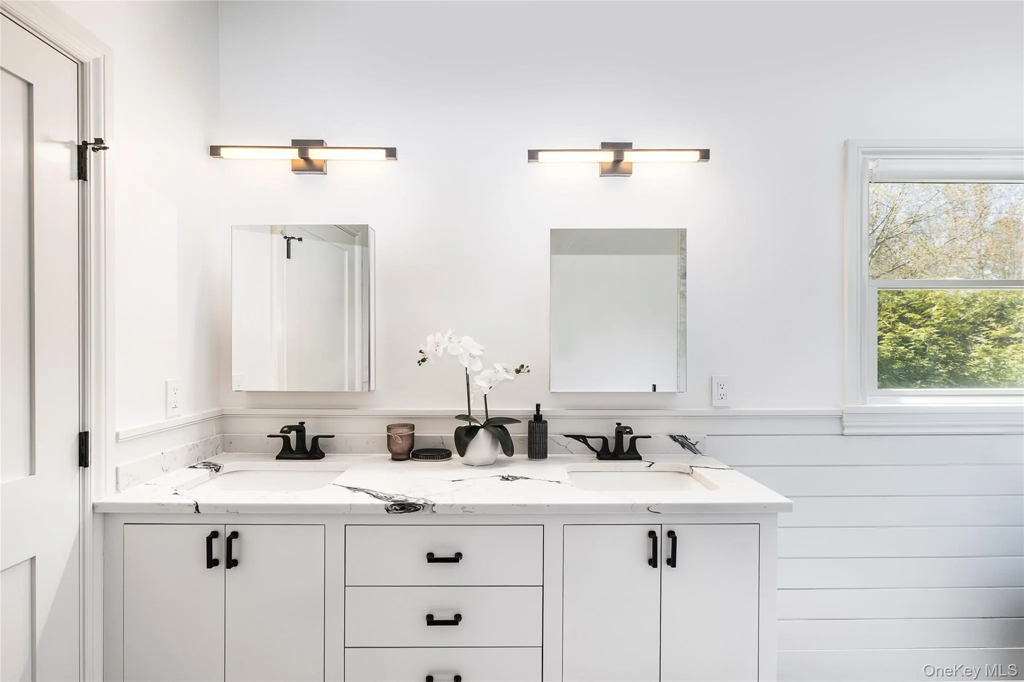 Full bathroom with a sink, a wainscoted wall, and double vanity Full bathroom with a sink, a wainscoted wall, and double vanity