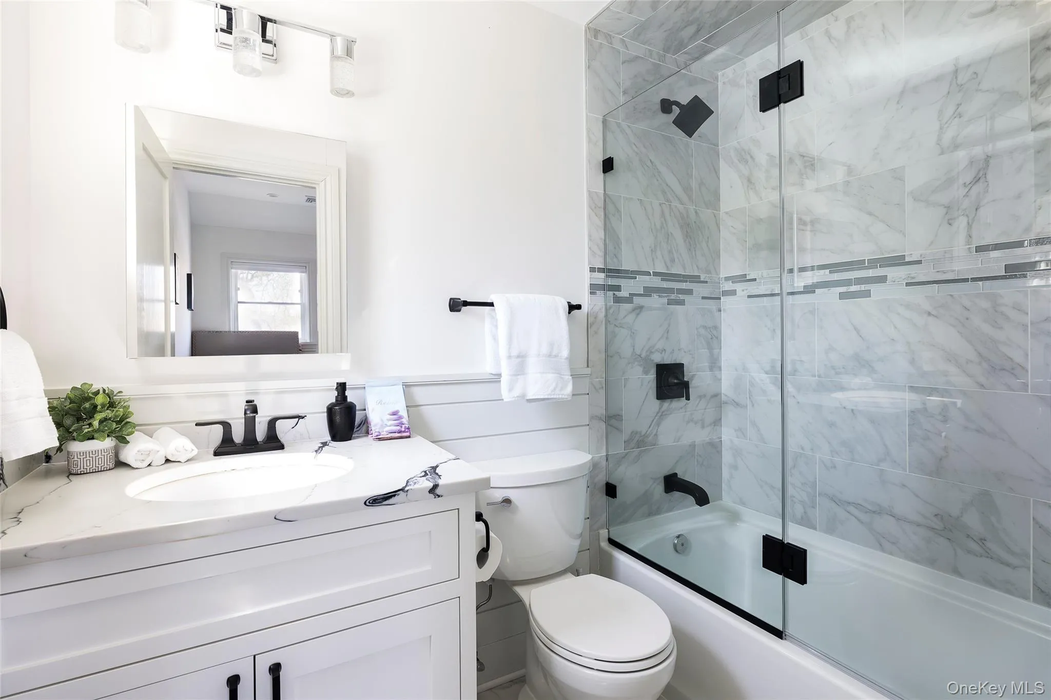 Bathroom with vanity, bath / shower combo with glass door, and toilet Bathroom with vanity, bath / shower combo with glass door, and toilet