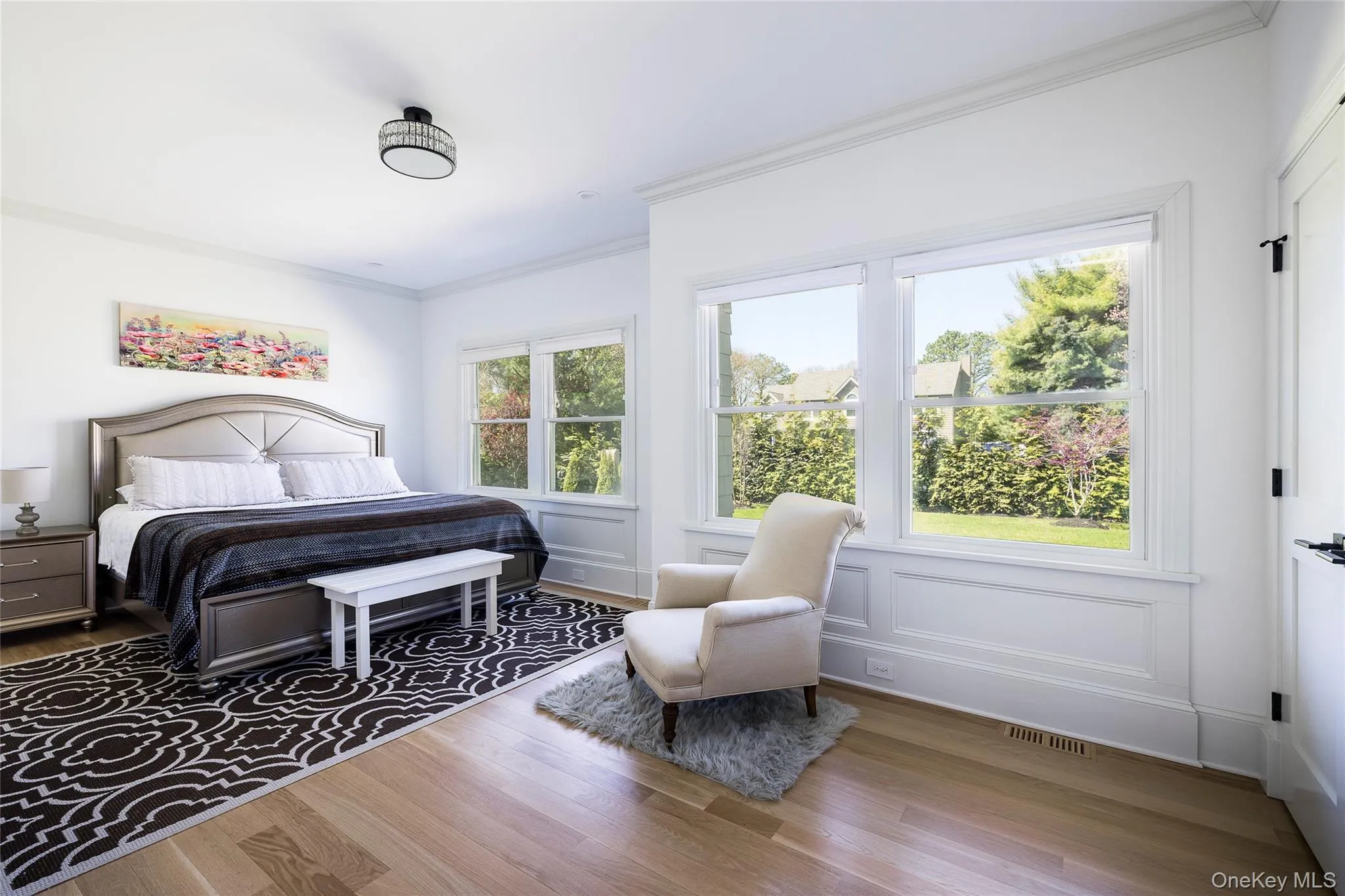 Bedroom with crown molding, wood finished floors, and visible vents Bedroom with crown molding, wood finished floors, and visible vents