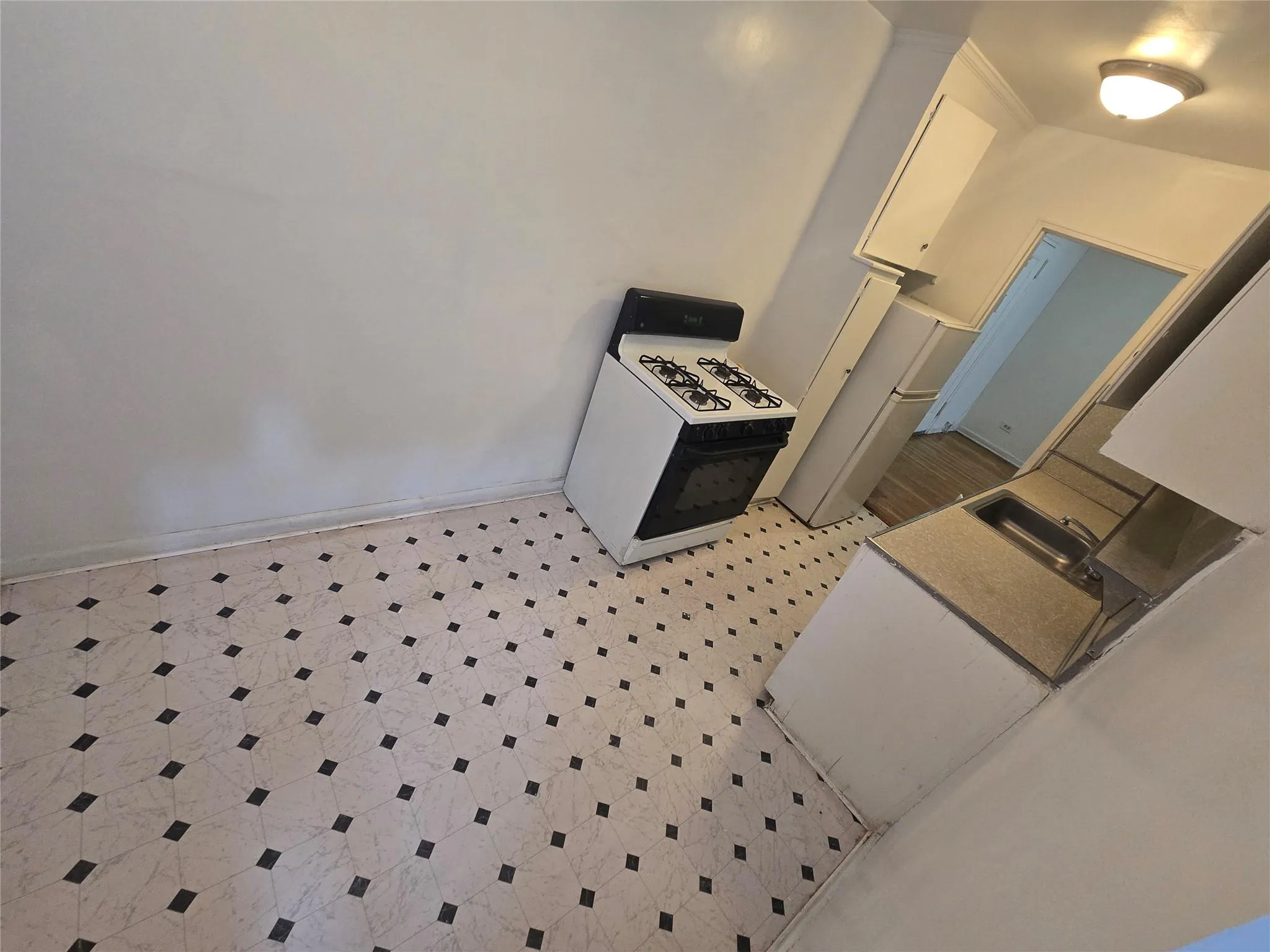 Kitchen featuring a sink, baseboards, white range with gas cooktop, light floors, and ornamental molding Kitchen featuring a sink, baseboards, white range with gas cooktop, light floors, and ornamental molding