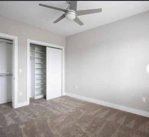Unfurnished bedroom featuring carpet floors, baseboards, a ceiling fan, and a closet Unfurnished bedroom featuring carpet floors, baseboards, a ceiling fan, and a closet