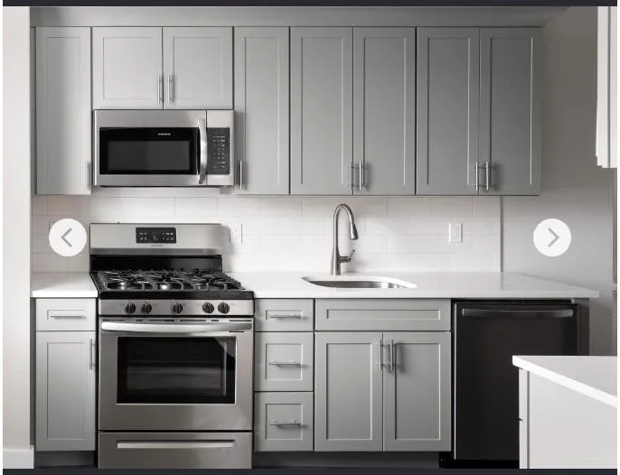 Kitchen featuring appliances with stainless steel finishes, a sink, gray cabinets, light countertops, and decorative backsplash Kitchen featuring appliances with stainless steel finishes, a sink, gray cabinets, light countertops, and decorative backsplash