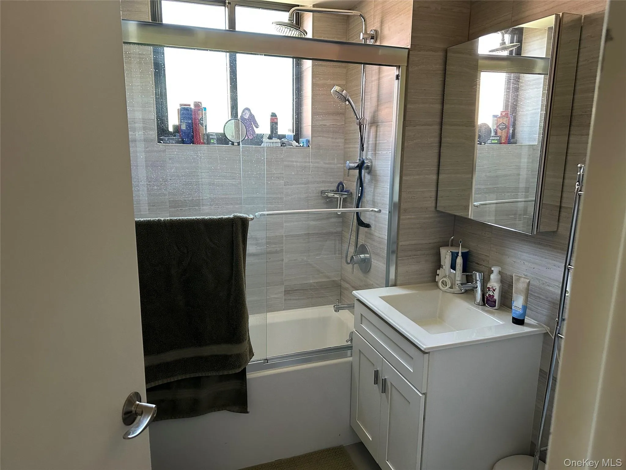 Bathroom featuring combined bath / shower with glass door and vanity Bathroom featuring combined bath / shower with glass door and vanity