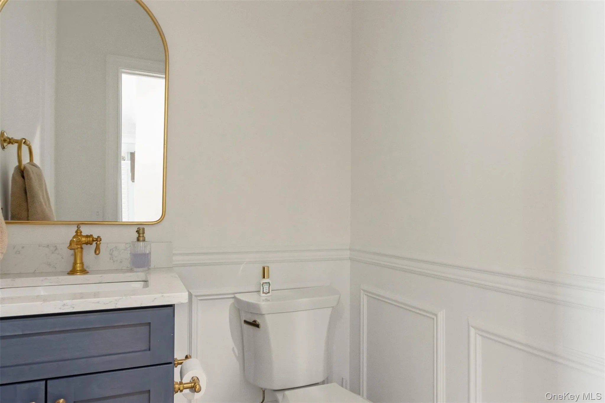 Bathroom with toilet, a wainscoted wall, and vanity Bathroom with toilet, a wainscoted wall, and vanity