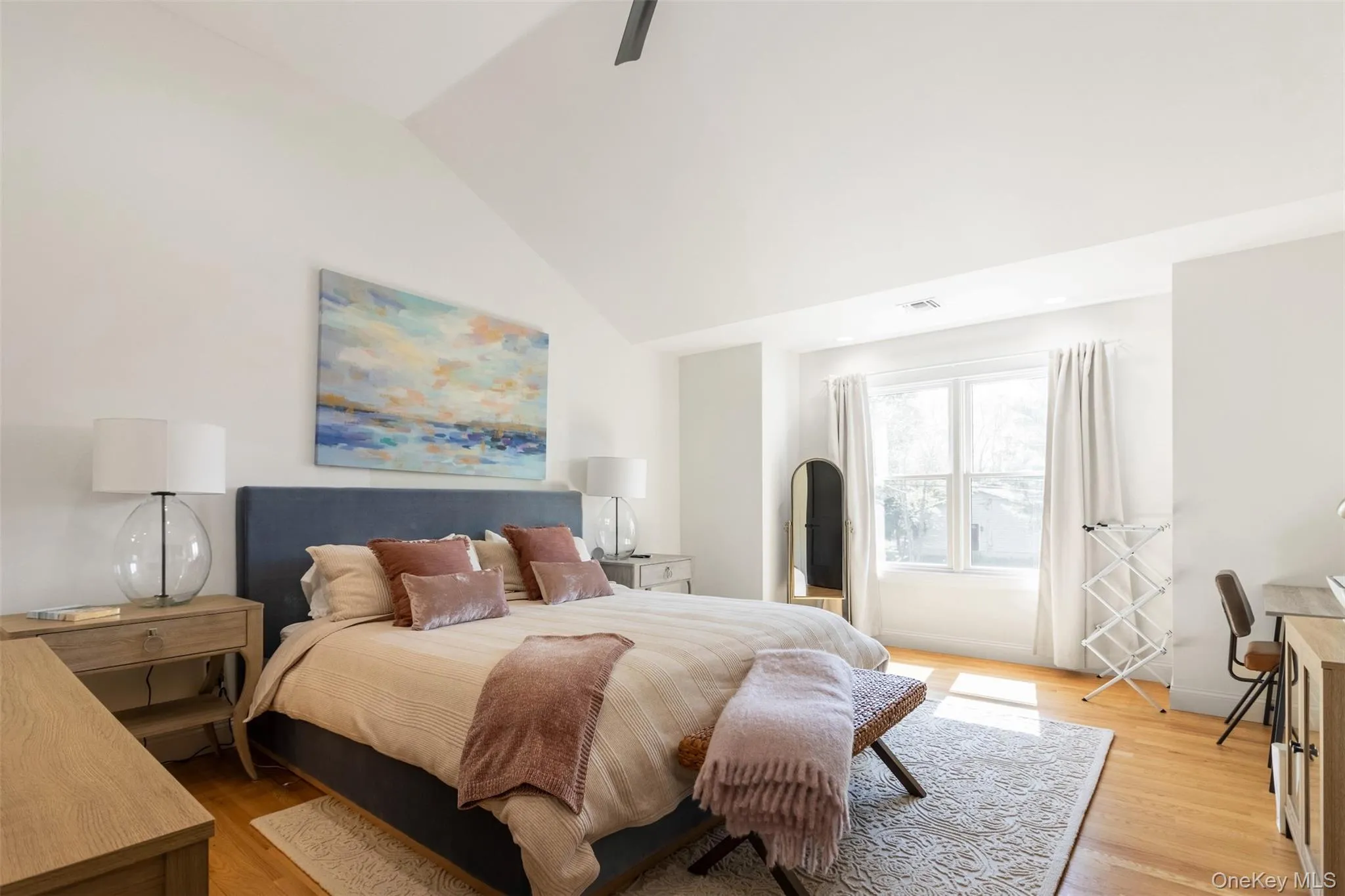 Bedroom with light wood-style flooring and lofted ceiling Bedroom with light wood-style flooring and lofted ceiling