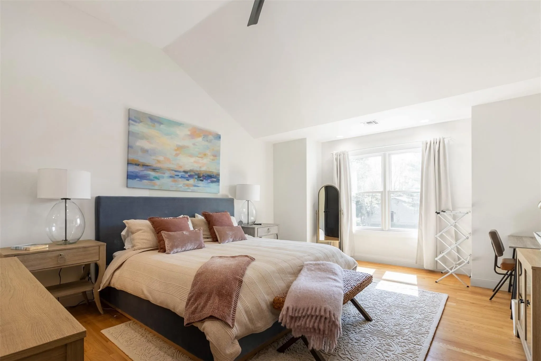 Bedroom with light wood-style flooring and lofted ceiling Bedroom with light wood-style flooring and lofted ceiling