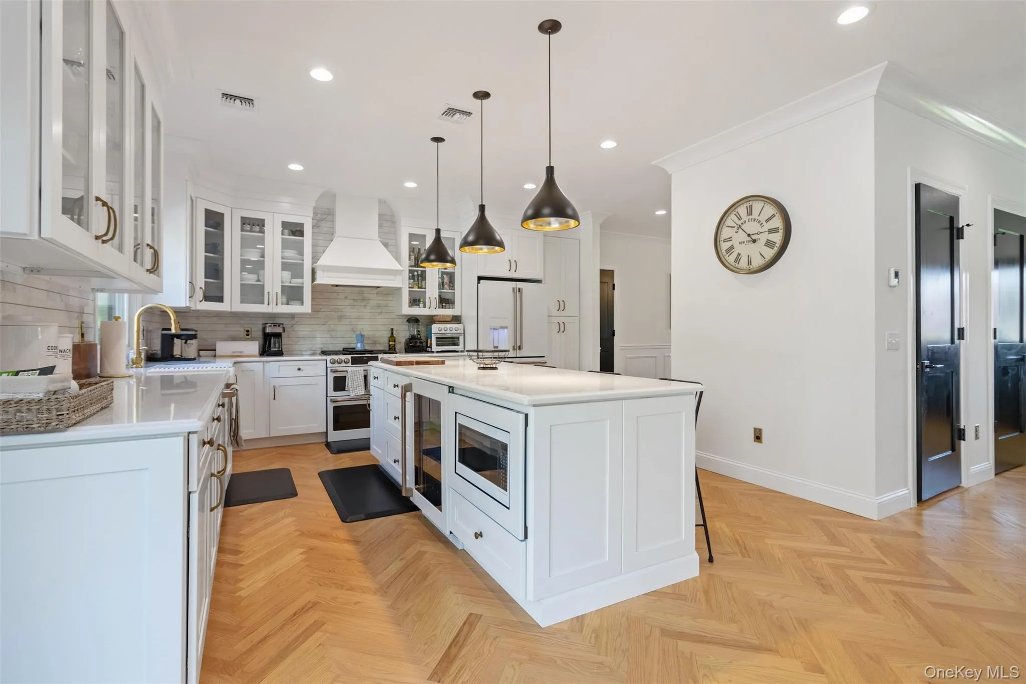 Kitchen with visible vents, custom exhaust hood, white refrigerator with ice dispenser, light countertops, and a sink Kitchen with visible vents, custom exhaust hood, white refrigerator with ice dispenser, light countertops, and a sink