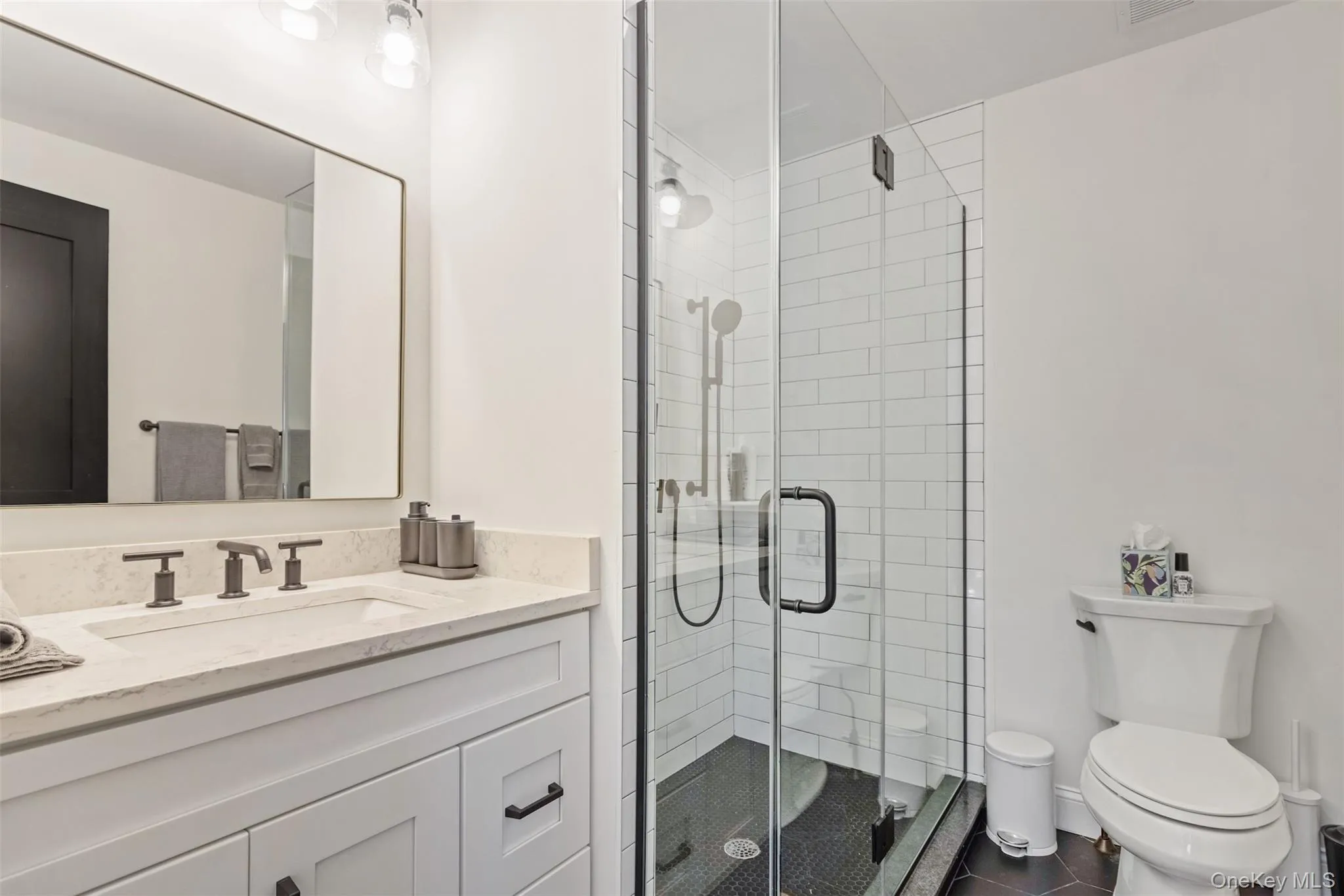 Full bathroom with vanity, tile patterned floors, toilet, and a shower stall Full bathroom with vanity, tile patterned floors, toilet, and a shower stall