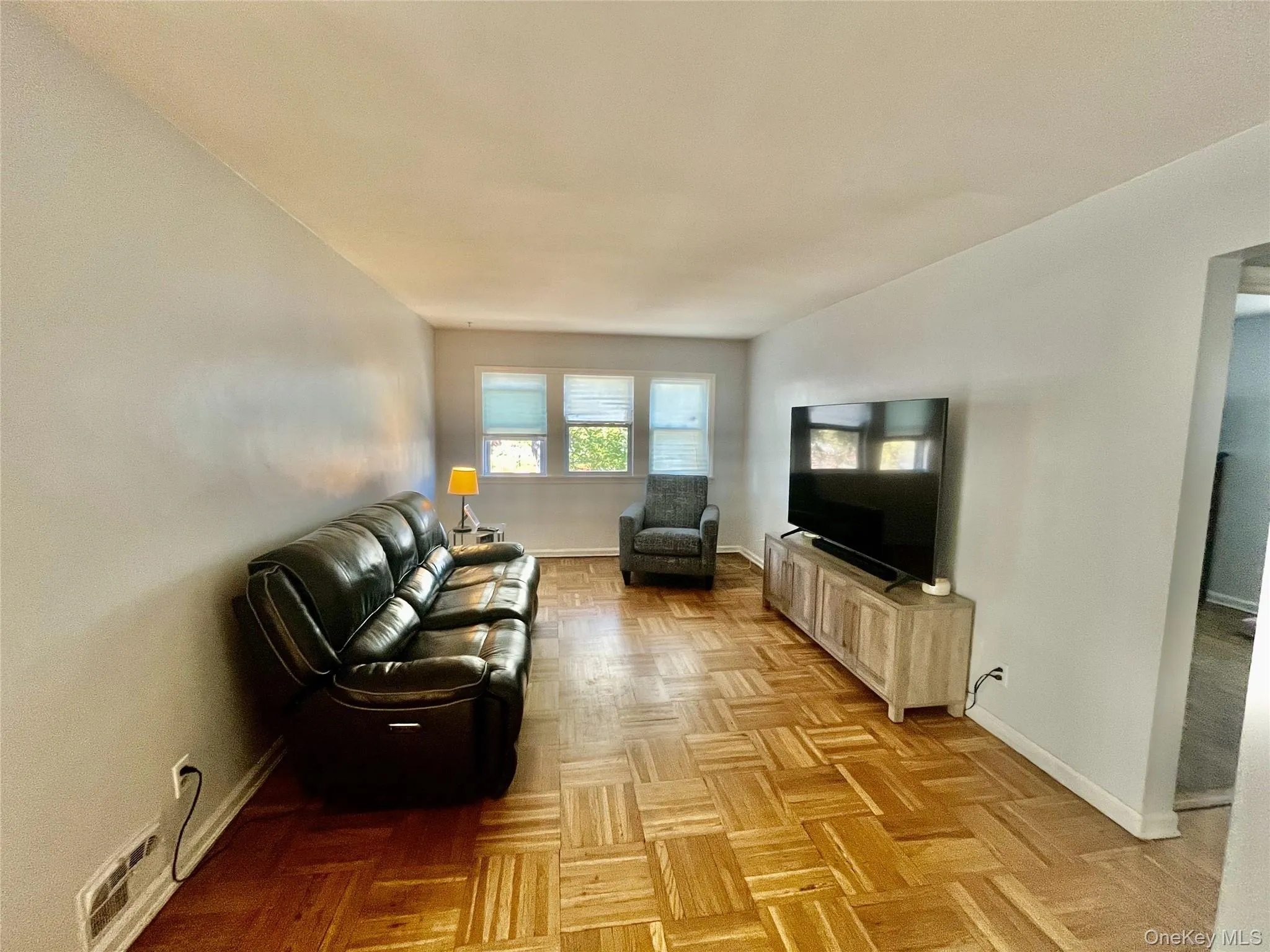 Living area with baseboards and visible vents Living area with baseboards and visible vents