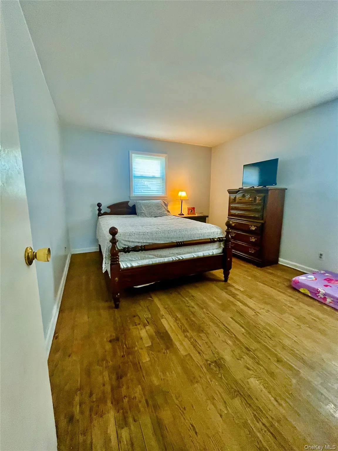Bedroom featuring baseboards and wood finished floors Bedroom featuring baseboards and wood finished floors