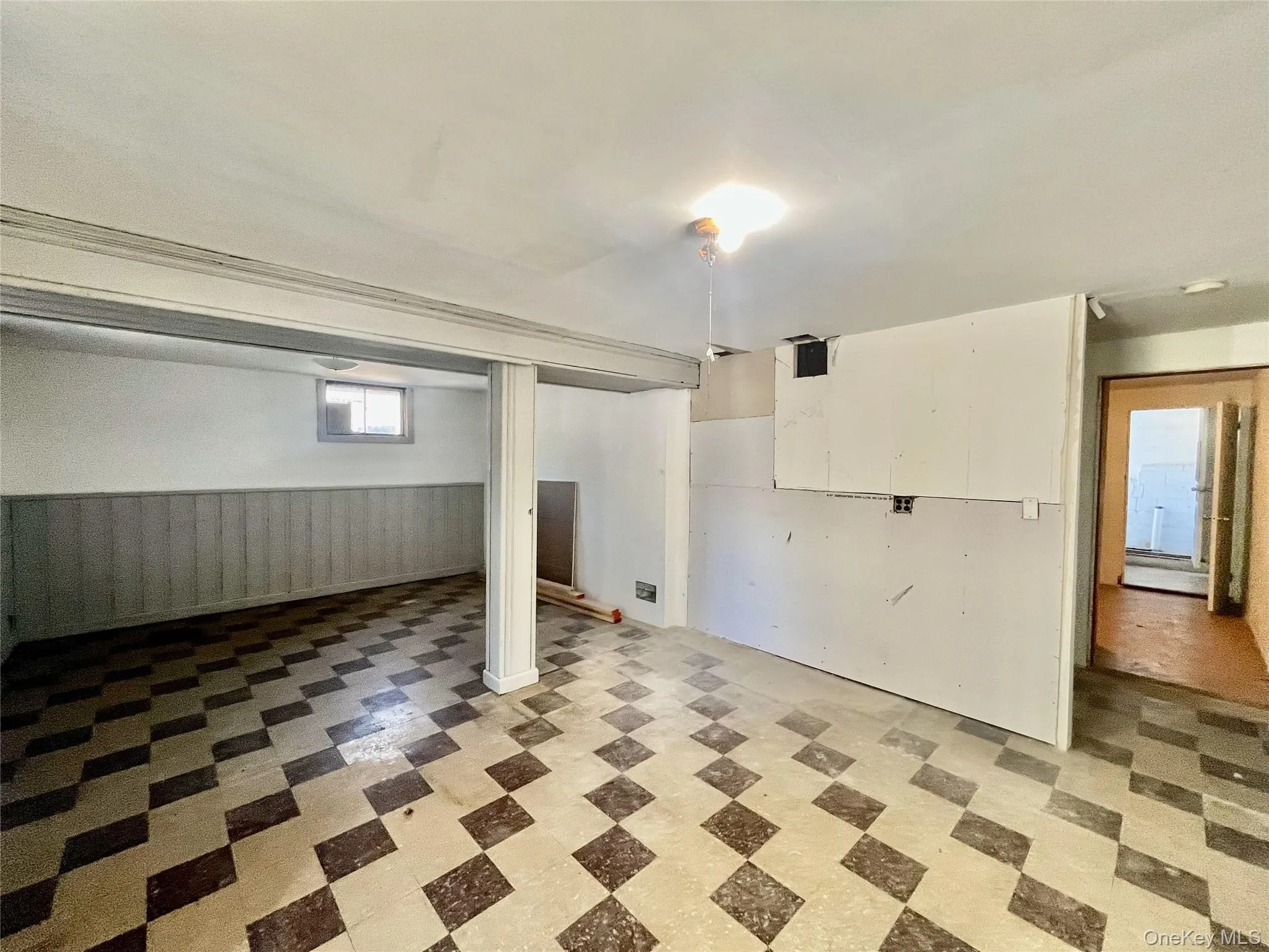Below grade area featuring light floors and wainscoting Below grade area featuring light floors and wainscoting