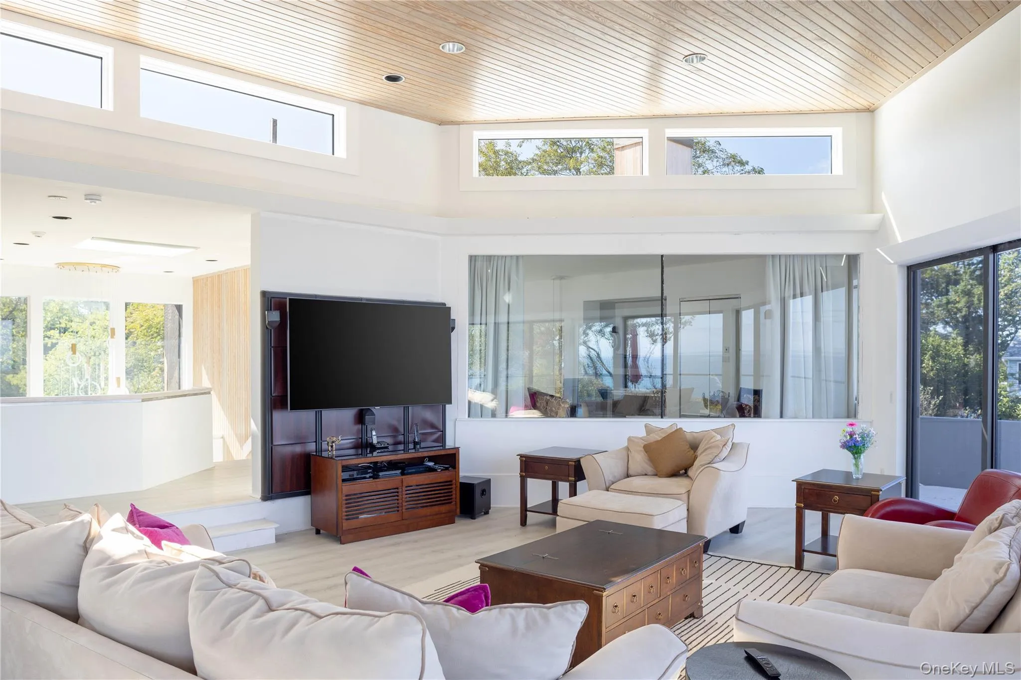 Living area featuring wood ceiling, a high ceiling, and a wealth of natural light Living area featuring wood ceiling, a high ceiling, and a wealth of natural light