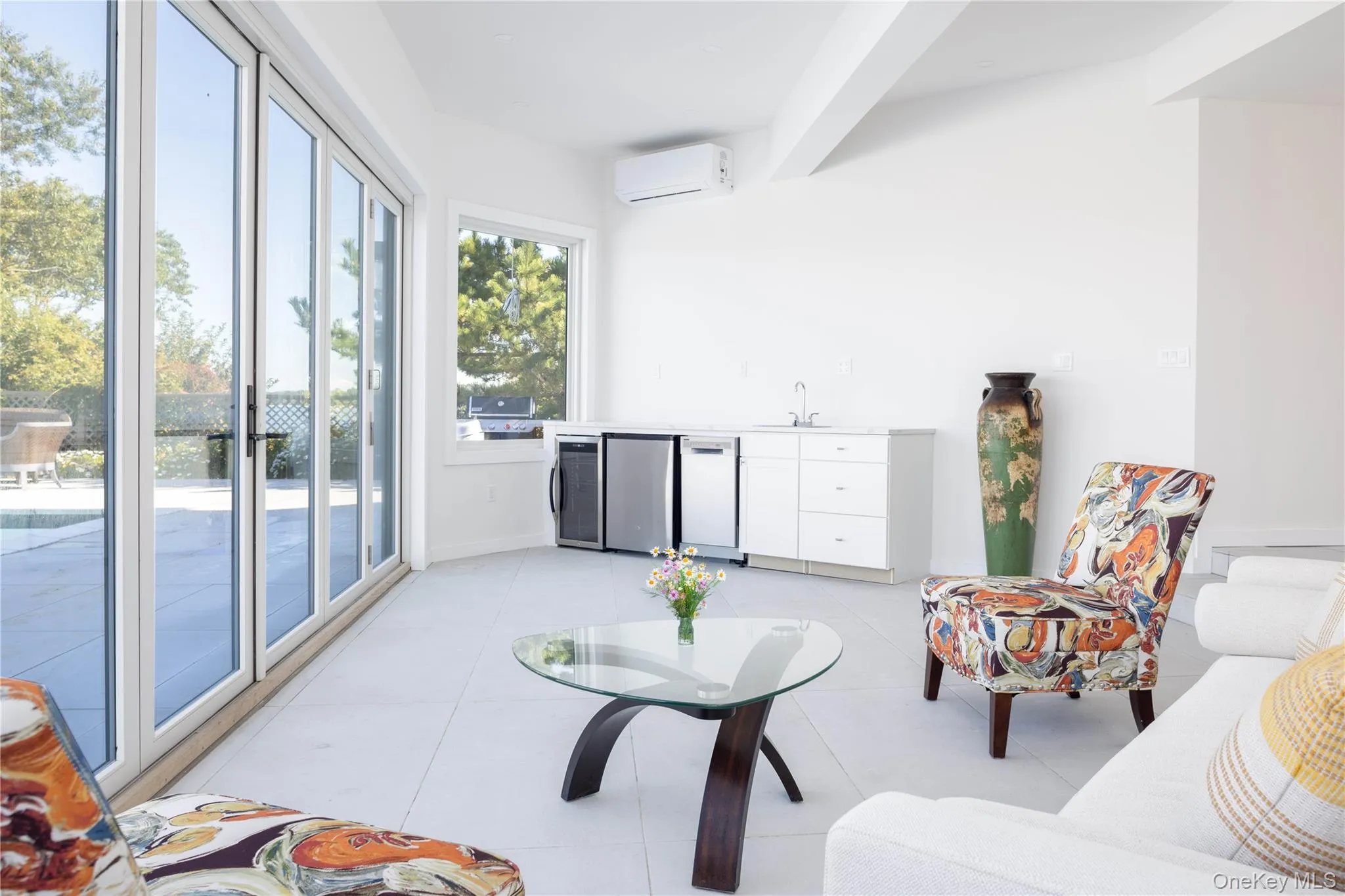 Sunroom featuring a wall mounted AC and a sink Sunroom featuring a wall mounted AC and a sink