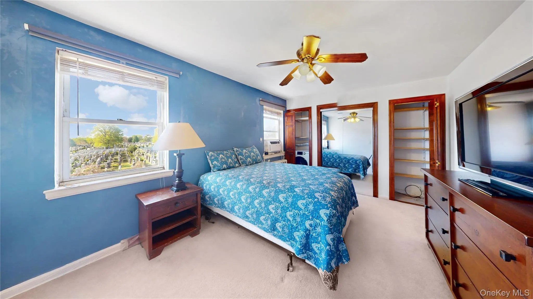 Bedroom featuring carpet, cooling unit, two closets, baseboards, and ceiling fan Bedroom featuring carpet, cooling unit, two closets, baseboards, and ceiling fan