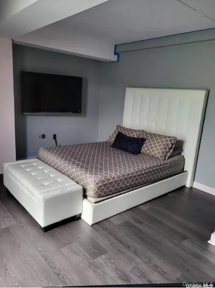 Bedroom featuring baseboards and wood finished floors Bedroom featuring baseboards and wood finished floors