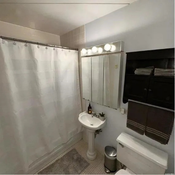 Full bath with toilet and tile patterned floors Full bath with toilet and tile patterned floors
