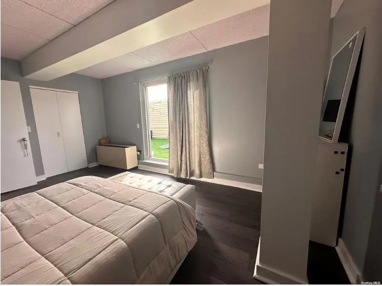 Bedroom featuring baseboards, a closet, and wood finished floors Bedroom featuring baseboards, a closet, and wood finished floors
