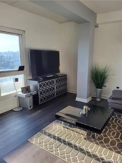 Living room featuring baseboards and wood finished floors Living room featuring baseboards and wood finished floors