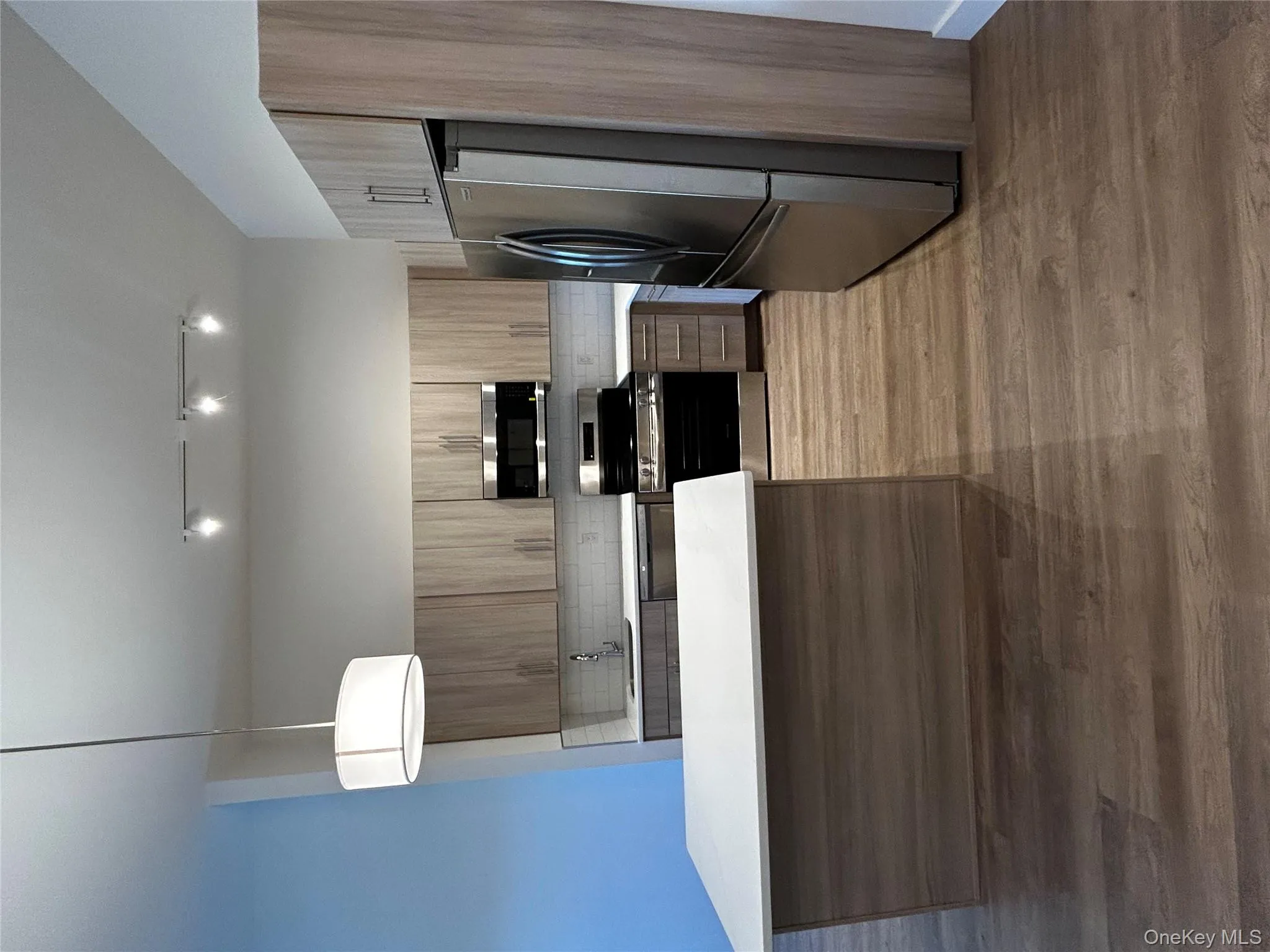 Kitchen featuring decorative backsplash, stainless steel electric range oven, modern cabinets, refrigerator, and light countertops Kitchen featuring decorative backsplash, stainless steel electric range oven, modern cabinets, refrigerator, and light countertops