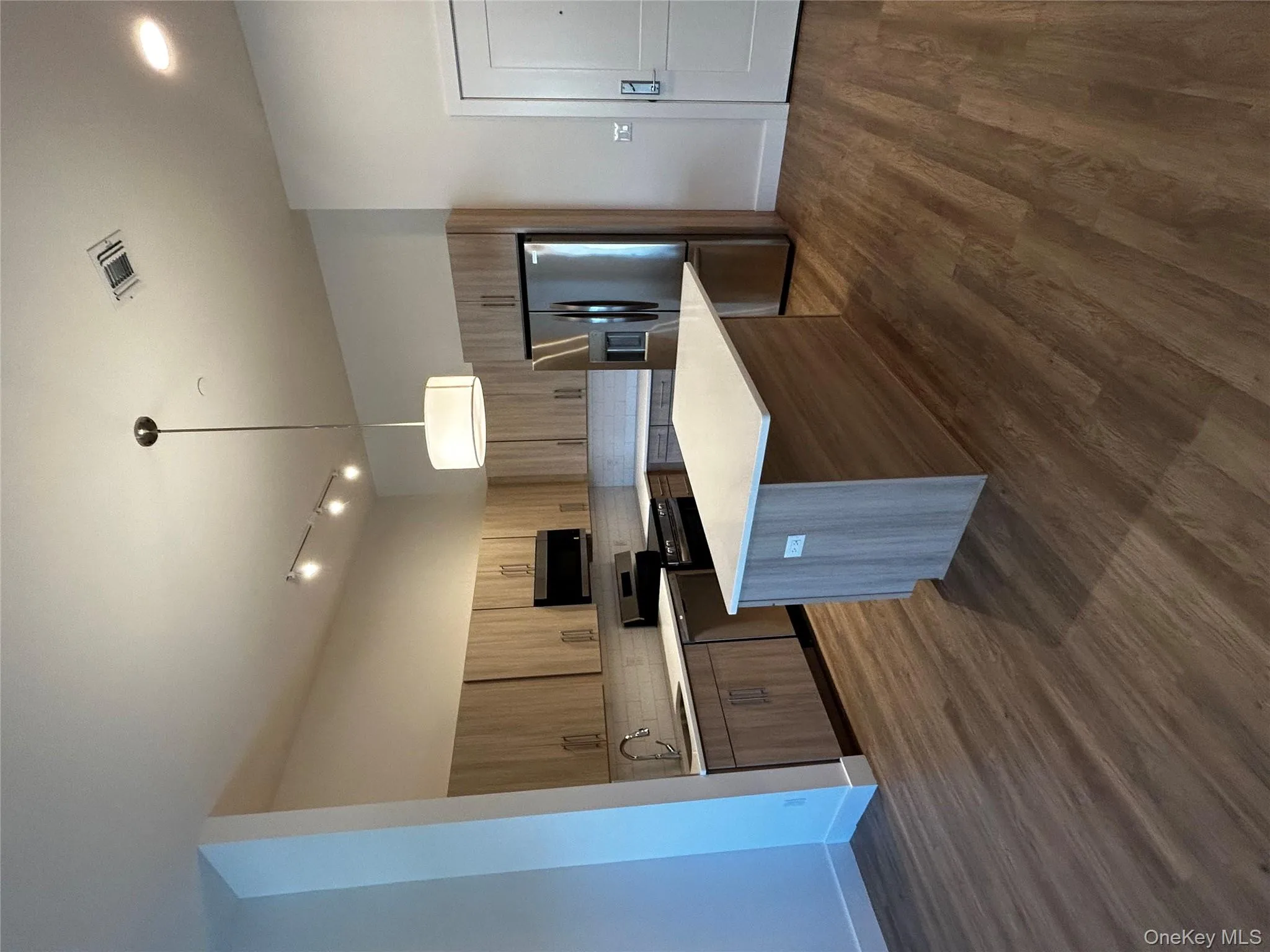 Kitchen with decorative backsplash, visible vents, range, fridge, and light countertops Kitchen with decorative backsplash, visible vents, range, fridge, and light countertops