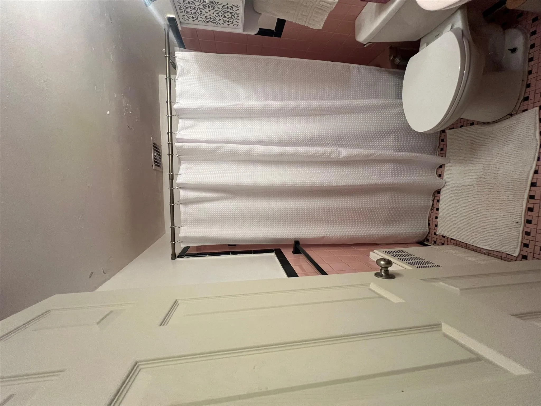 Bathroom featuring toilet, tile walls, curtained shower, and visible vents Bathroom featuring toilet, tile walls, curtained shower, and visible vents