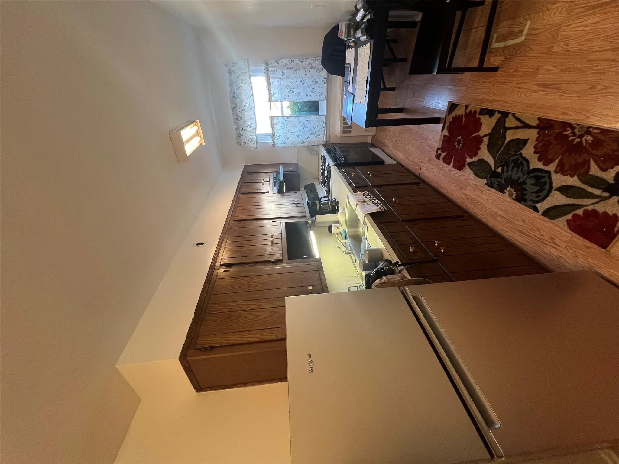 Kitchen featuring dark brown cabinetry, refrigerator, a sink, light wood-style flooring, and range Kitchen featuring dark brown cabinetry, refrigerator, a sink, light wood-style flooring, and range