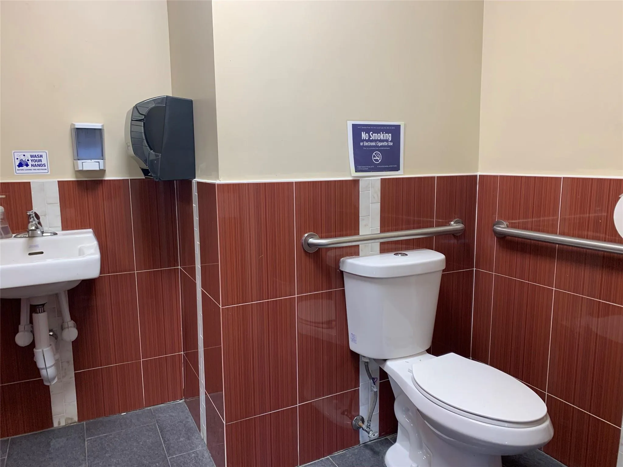 Bathroom featuring a wainscoted wall, toilet, and tile walls Bathroom featuring a wainscoted wall, toilet, and tile walls