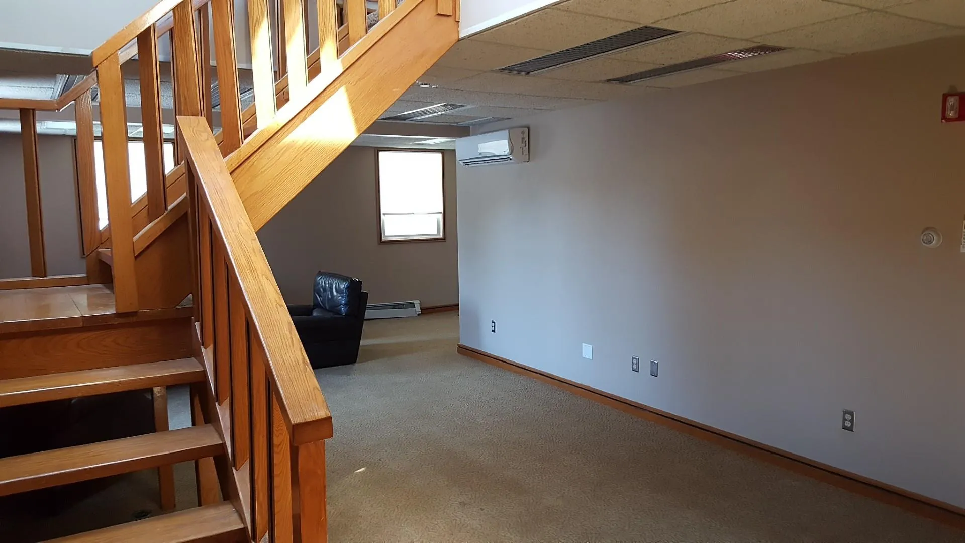 Staircase with a wall mounted air conditioner, carpet, a baseboard heating unit, baseboards, and a paneled ceiling Staircase with a wall mounted air conditioner, carpet, a baseboard heating unit, baseboards, and a paneled ceiling