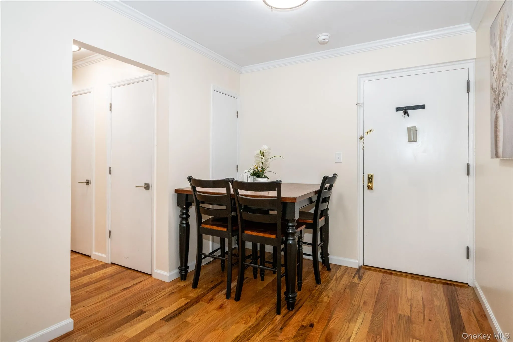 Dining room with crown molding, wood finished floors, and baseboards Dining room with crown molding, wood finished floors, and baseboards