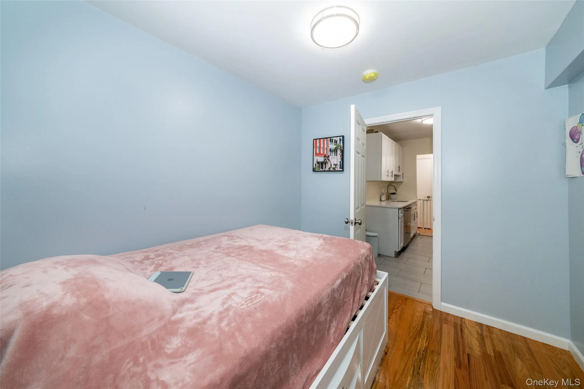 Bedroom featuring a sink, light wood-style floors, and baseboards Bedroom featuring a sink, light wood-style floors, and baseboards