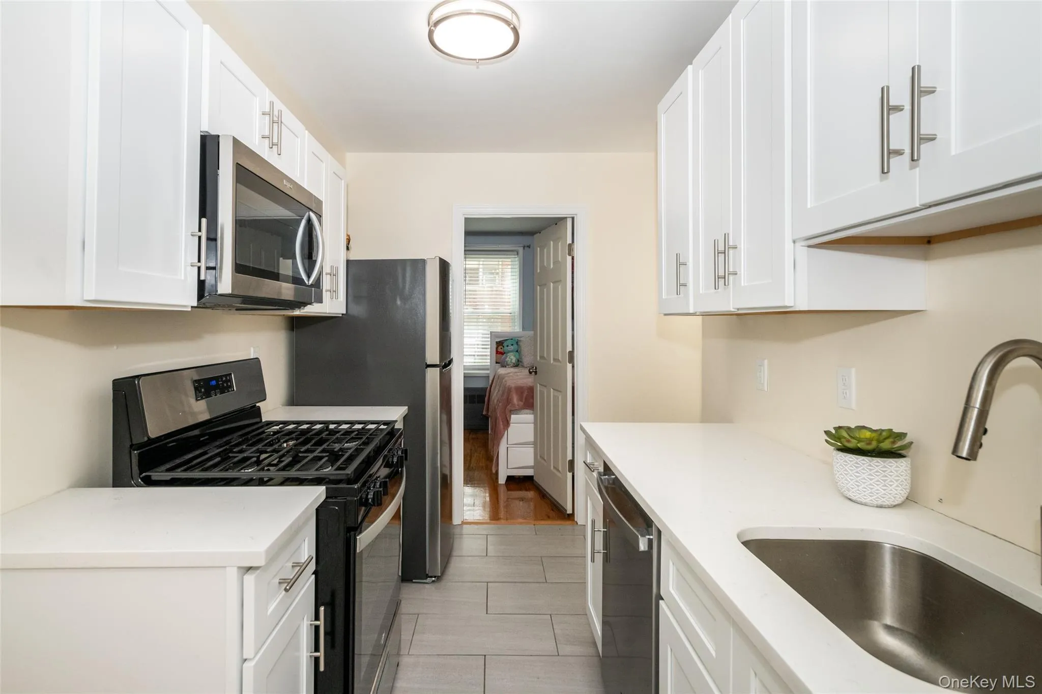 Featuring stainless steel appliances, a sink, and white cabinets Featuring stainless steel appliances, a sink, and white cabinets
