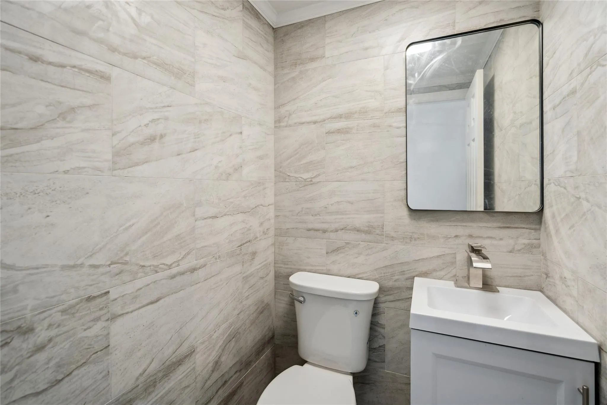 Bathroom featuring toilet, tile walls, vanity, and crown molding Bathroom featuring toilet, tile walls, vanity, and crown molding