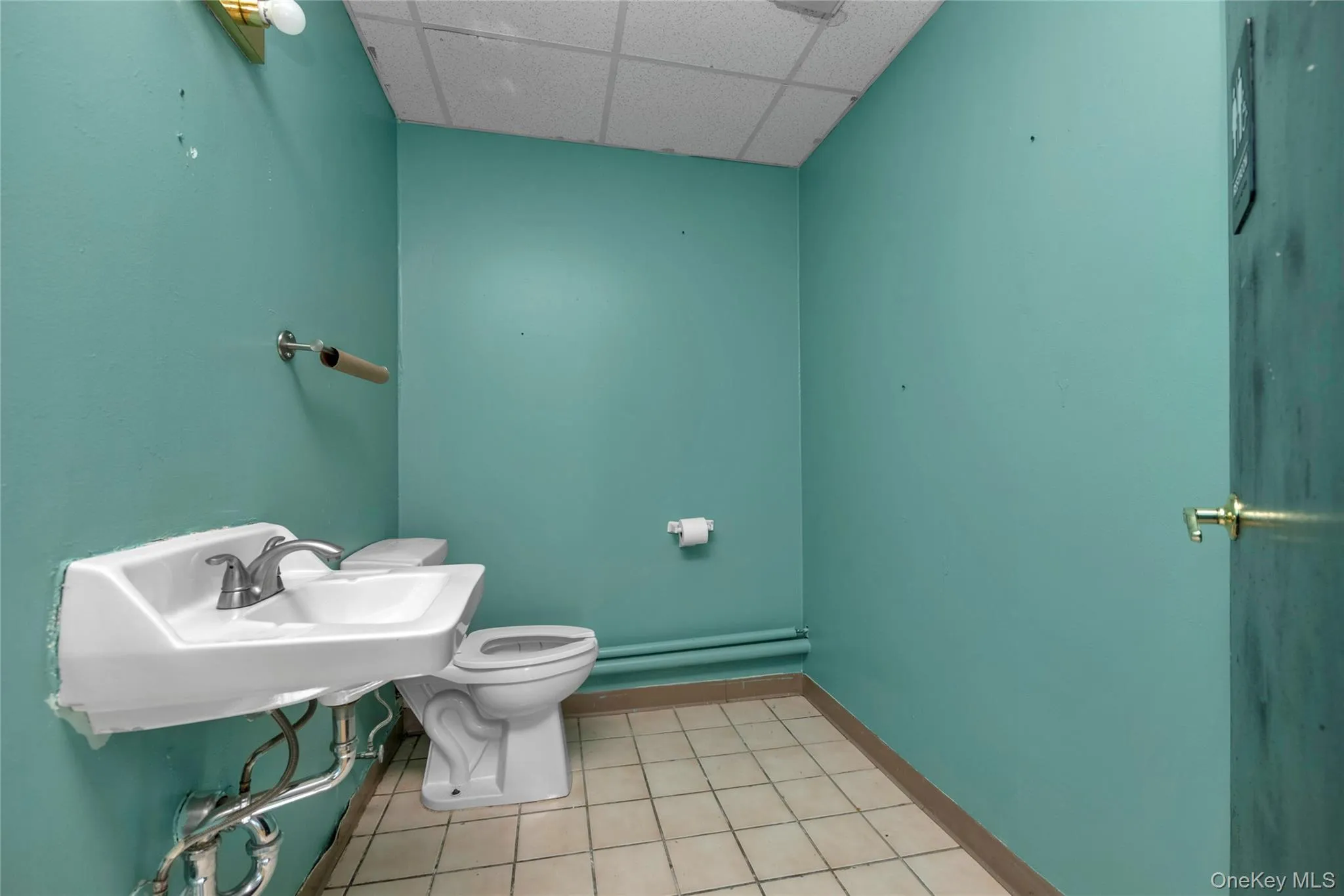 Bathroom featuring a paneled ceiling and toilet Bathroom featuring a paneled ceiling and toilet