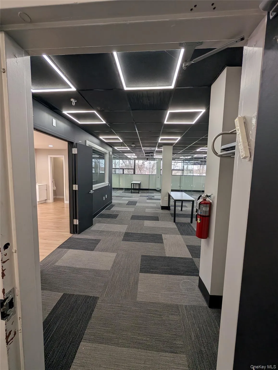 Hallway featuring light carpet and baseboards Hallway featuring light carpet and baseboards