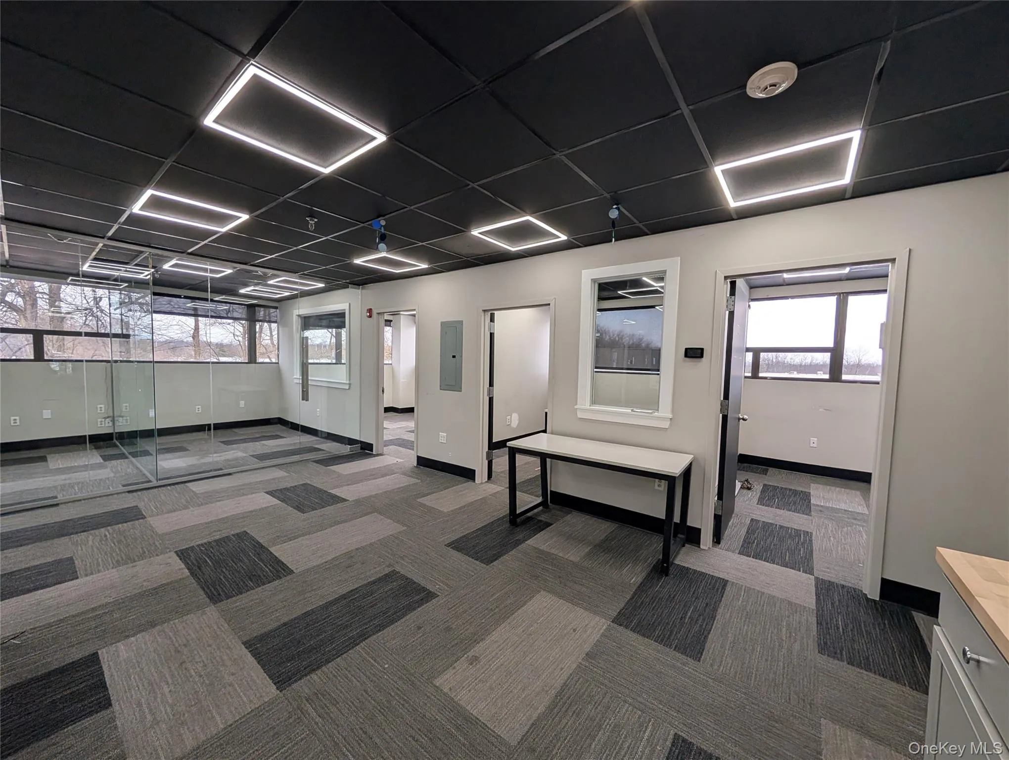 Lobby featuring a paneled ceiling and electric panel Lobby featuring a paneled ceiling and electric panel
