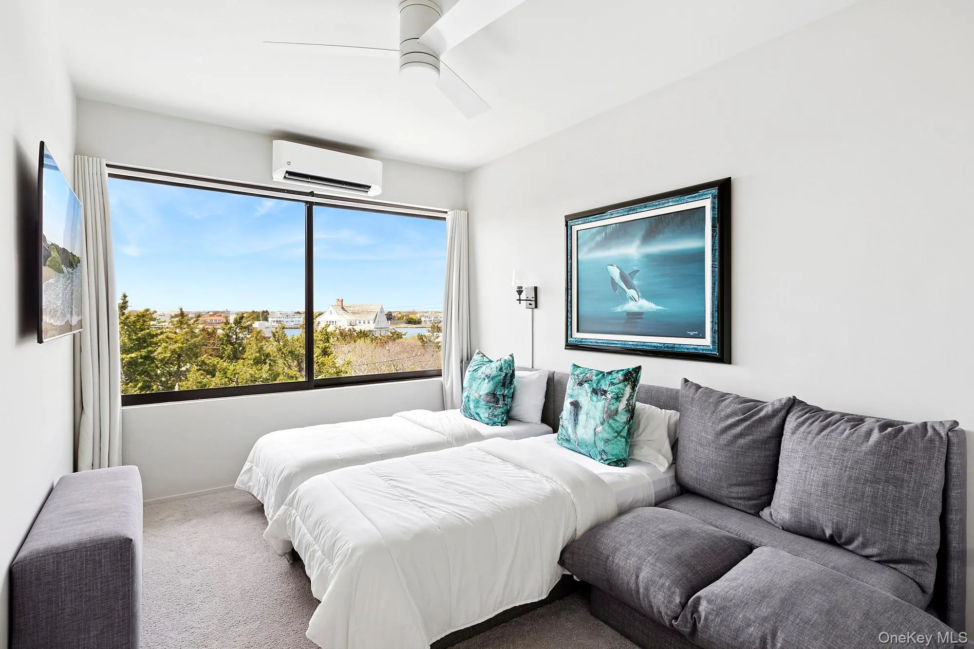 Carpeted bedroom featuring ceiling fan and a wall mounted AC