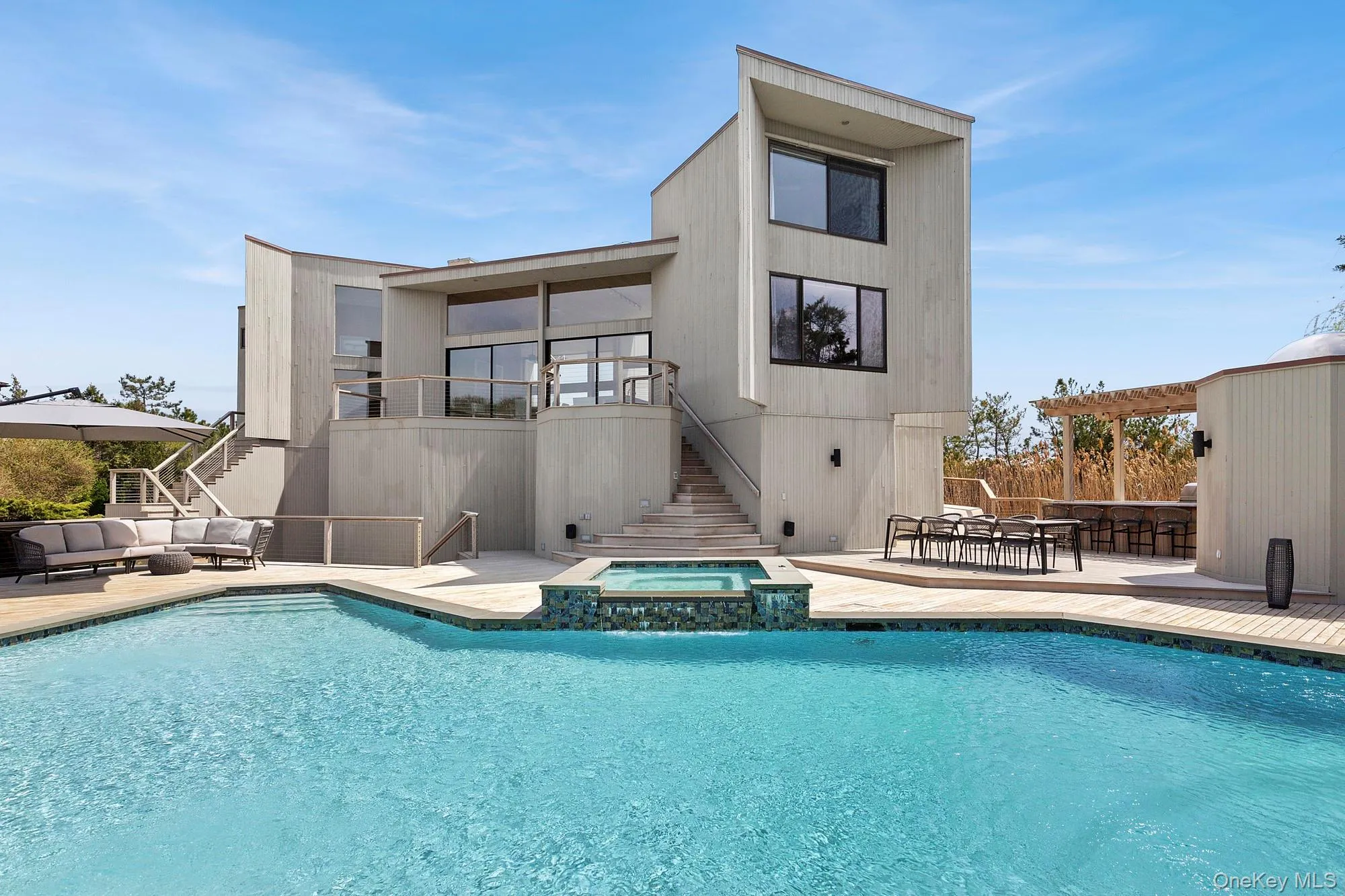 Rear view of property with stairway, a patio, an outdoor living space, and a pool with connected hot tub
